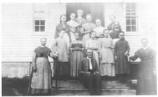 SA0214 - An unidentified Shaker group of men, women and children on the steps to a building.